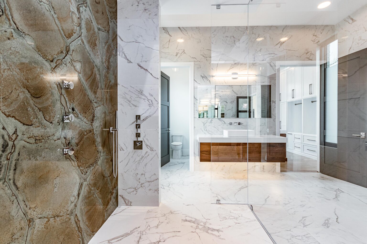Curbless walk-in shower with large format tile and frameless glass