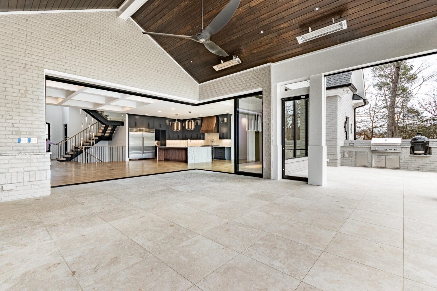 Panoramic folding glass doors opening a living space onto a covered porch