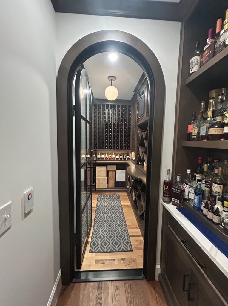 Custom walk-in wine cooler with glass doors and timber racking