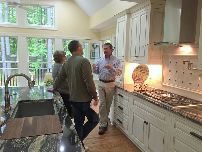 Wallace Baker walking homeowners through a finished TrendMark kitchen